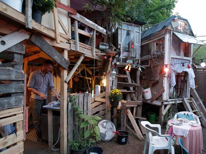 British set designer Tony Hornecker prepares dinner at his restaurant, "The Pale Blue Door." Made with scrap materials scavenged from the streets, it