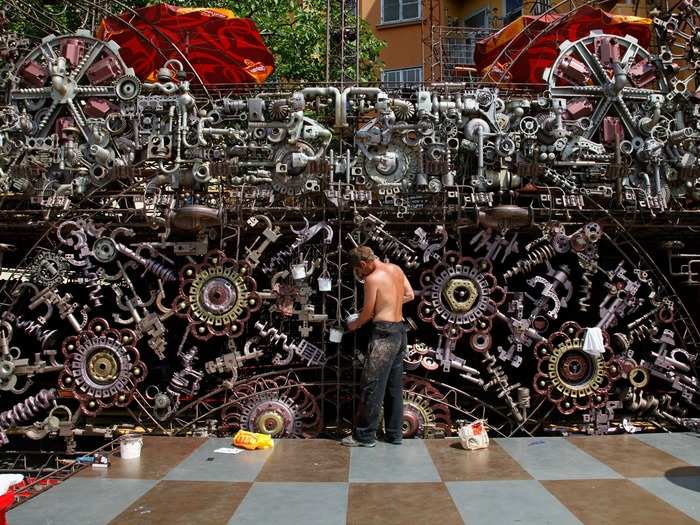 An employee paints the outer decoration of a cafe bar in Prague