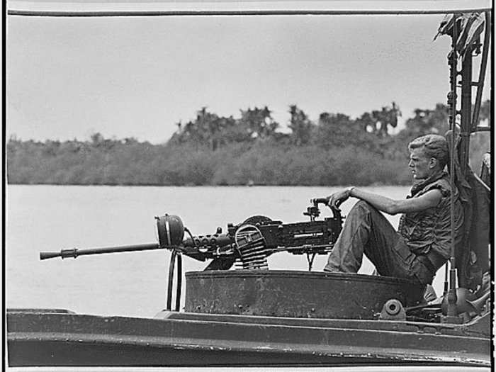 A crewman sits behind a machine gun while on patrol of the Go Cong River. Fighting in dense jungle against well-supplied Viet Cong left American troops frustrated with combat conditions. It was after this war that "Post Traumatic Stress Disorder" was officially identified.