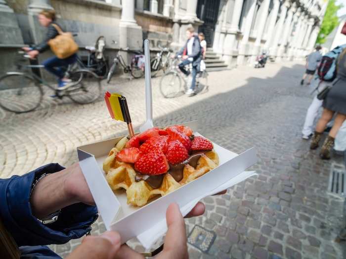 Indulge in fresh gaufres chaudes (hot waffles) topped with strawberries, whipped cream, Nutella, and more in Belgium.