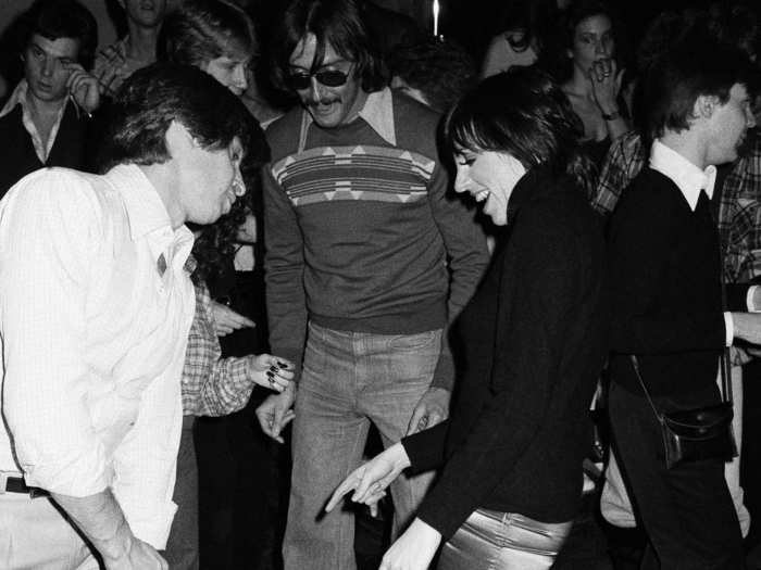 Designer Roy Halston Frowick (or just Halston), Andy Warhol, and Liza Minelli were always seen together at Studio 54. Minelli is pictured here teasing an unidentified man about his shoes as they meet on the floor before dancing.