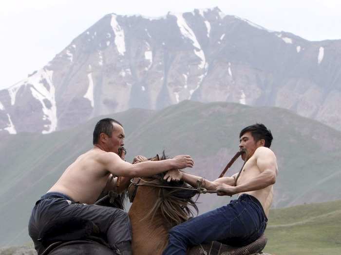 In Kyrgyzstan, men wrestle while riding horses as part of the national horse games and festival.