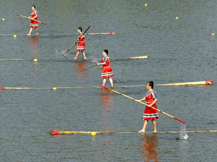 Single bamboo drifting was added to the Chinese Traditional Games of Ethnic Nationalities in Guangzhou, China, several years ago. It involves standing on seven-meter-long bamboo poles and using a much thinner bamboo as an oar to glide through the water.