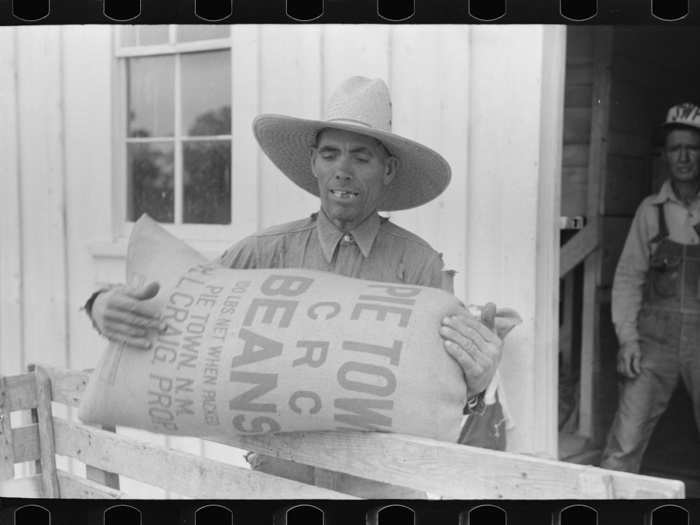 Mr. Leatherman loads a sack of pinto beans into his cart in Pie Town, New Mexico. It is customary for the farmers to leave their beans at the warehouse during the winter months.