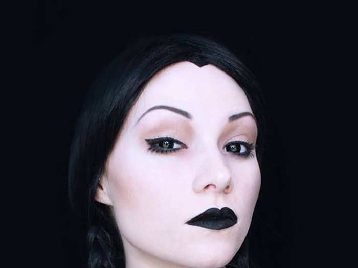 Dramatic makeup brings this Wednesday Addams-inspired costume to life.