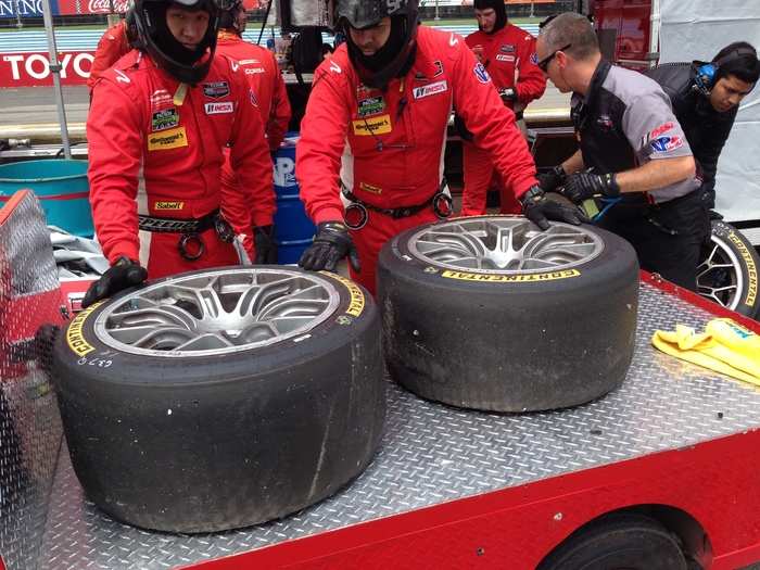 The pit crew inspects a set of tires after one of the cars experienced a brush with the wall. Tire wear can indicate whether there