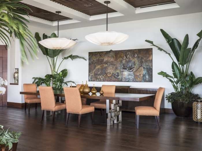 Large palm trees and dark woods mix well with the cabana-style furniture.