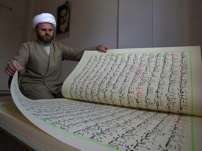 Hassan al-Zayyat shows off Koranic verses that he had copied by hand on 39- by 28-inch paper, aspiring to enter the Guinness Book of World Records for the largest handwritten Koran.