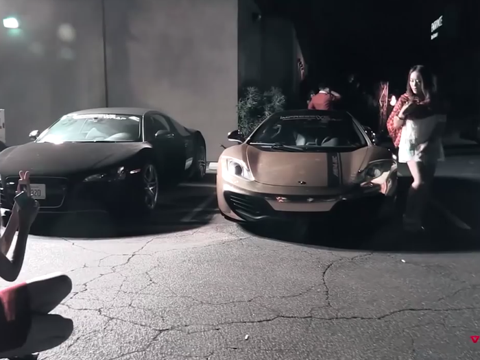 Some kids want to share their experiences on social media. Here, a young lady strikes a pose next to a gilded $250,000 McLaren MP4-12C supercar and a black $120,000 Audi R8.