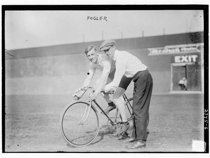 A guy riding a bike in the outfield.