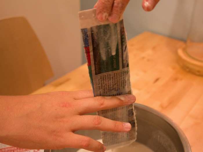 Dip strips of newspaper into your papier maché. Make sure to wipe off any excess so the strip isn