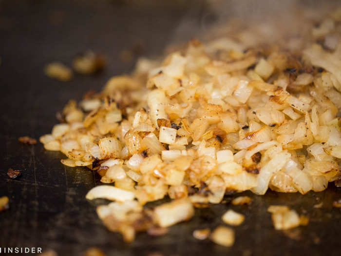 Meanwhile, another cook scrambled the caramelized onions sizzling on the griddle. Their aroma made my mouth water.