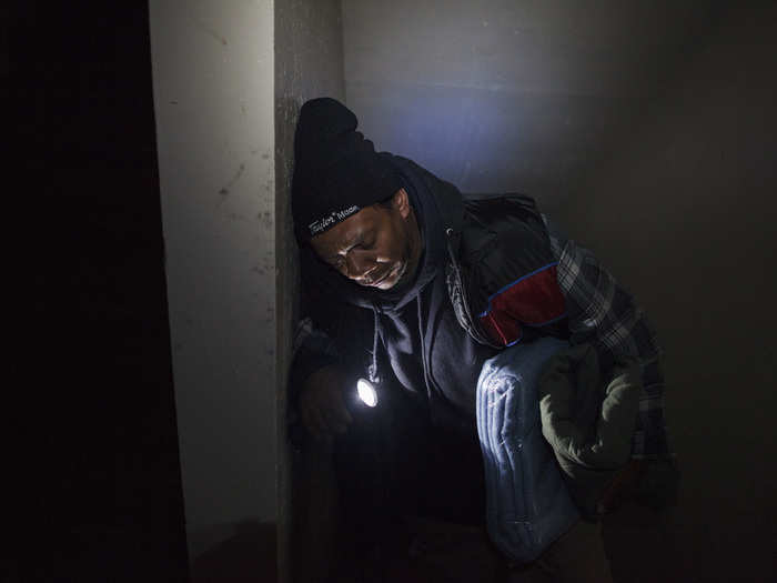 A man pauses to catch his breath as he walks up a darkened stairwell to his 15th floor apartment in Queens. His building lost power as a result of the storm.