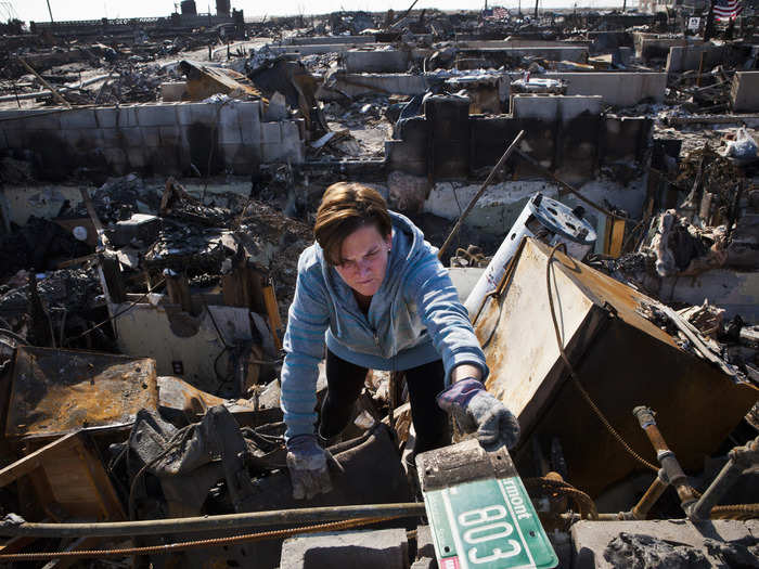 A woman helps sort through the remains of her father