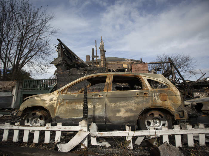 An automobile is seen parked among homes, all damaged by a fire and the effects of Sandy, in the Belle Harbor section of Queens.