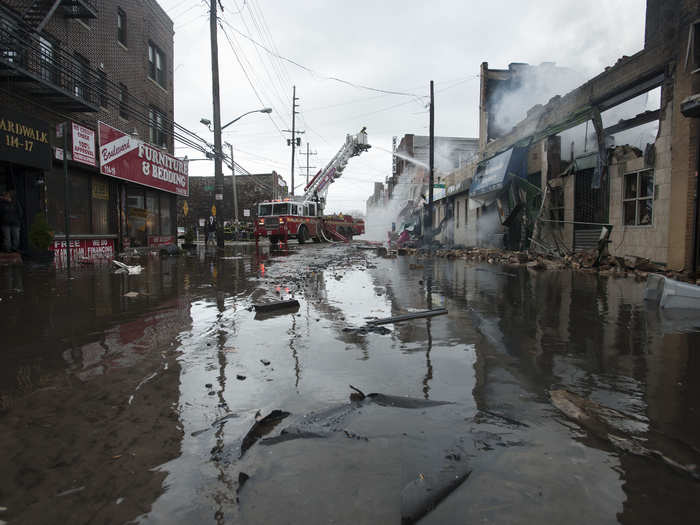 Firefighters work to extinguish a fire on a flooded street in the Rockaways section of Queens.