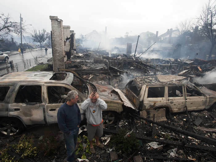 Residents look over the remains of burned homes in the Rockaways.