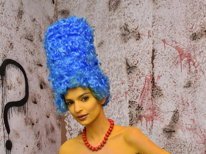 Model Emily Ratajkowski really committed to her Marge Simpson costume, wearing a blue wig and covering herself in yellow paint.