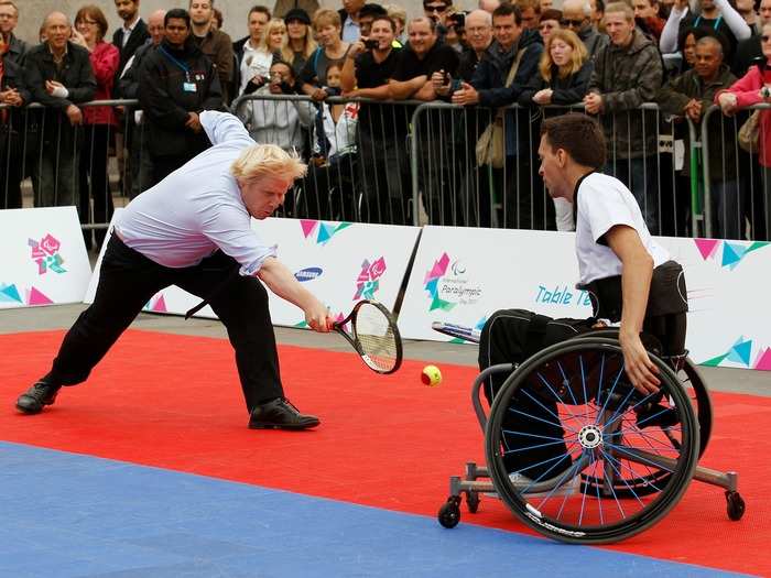 Johnson dives for the ball during a wheelchair tennis match on International Paralympic Day in 2011. He and his partner, Adam Field, were playing against Prime Minister David Cameron and John Parfitt.