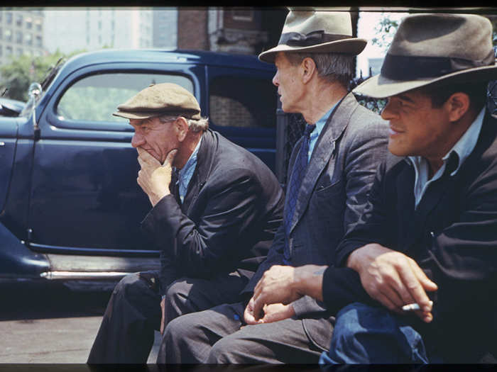 Three men sit on a bench in Battery Park during lunch hour.