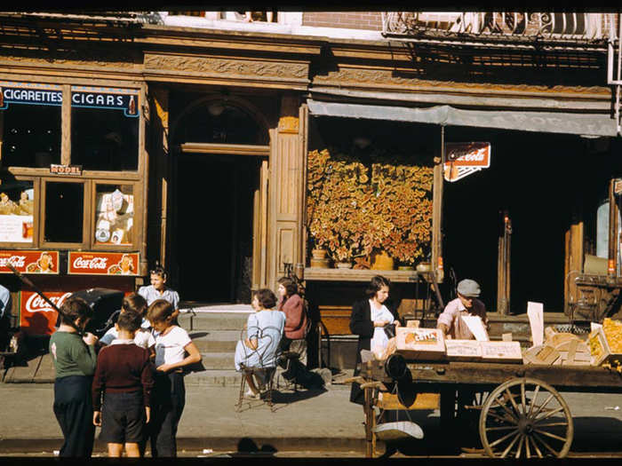 Children and adults gather outside various storefronts near the corner of Broome Street and Baruch Place on the Lower East Side.