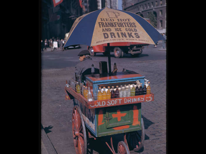 The hot dog carts in New York City have only gotten bigger and more elaborate since 1942. Here, a vendor waits for business in Bowling Green.