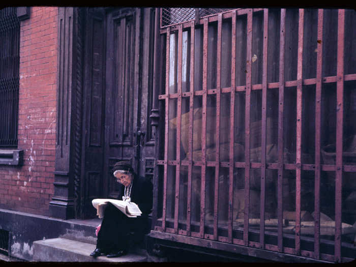 This woman enjoys her Sunday newspaper on a stoop in the Lower East Side.