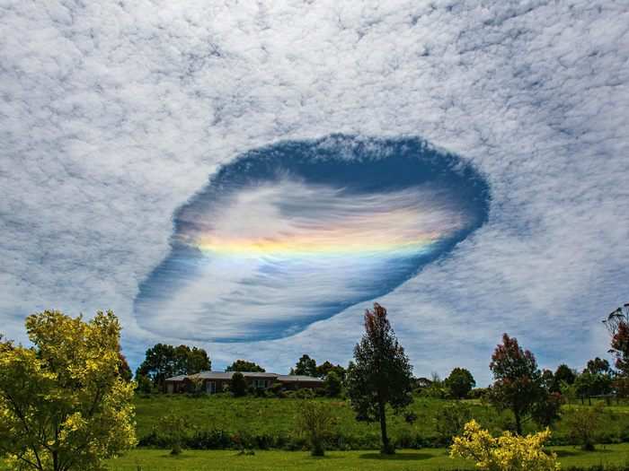 This fallstreak hole formed over eastern Victoria, Australia. Airplanes passing through the cirrocumulus or altocumulus clouds freeze the water droplets inside, punching a hole that can look like this.