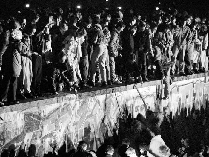 Both East and West German citizens celebrated as they climbed the wall at the Brandenburg Gate.