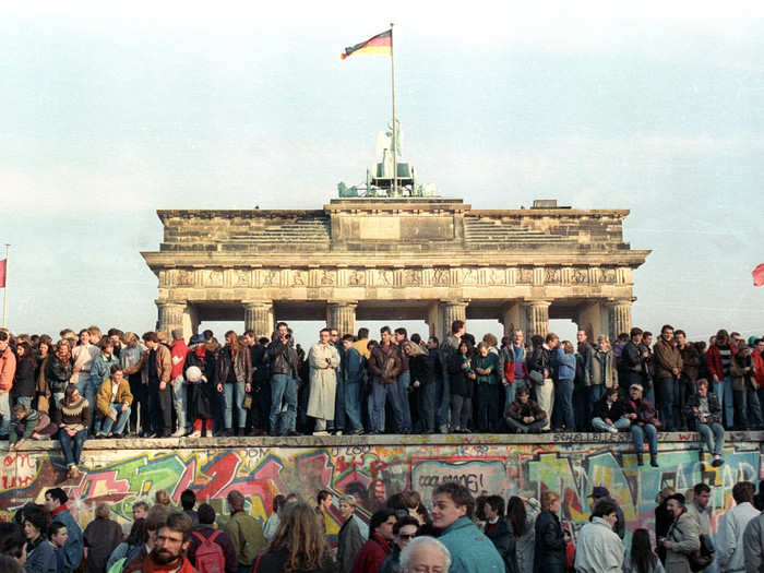 West Berlin citizens continued to stand atop the Berlin Wall, here, at Brandenburg Gate, on November 10.