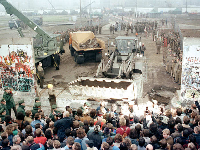 By November 12, it was no longer only small hammers being used to deconstruct the wall. Here, an East German bulldozer and crane knock down the Berlin Wall at Potsdamer Platz.