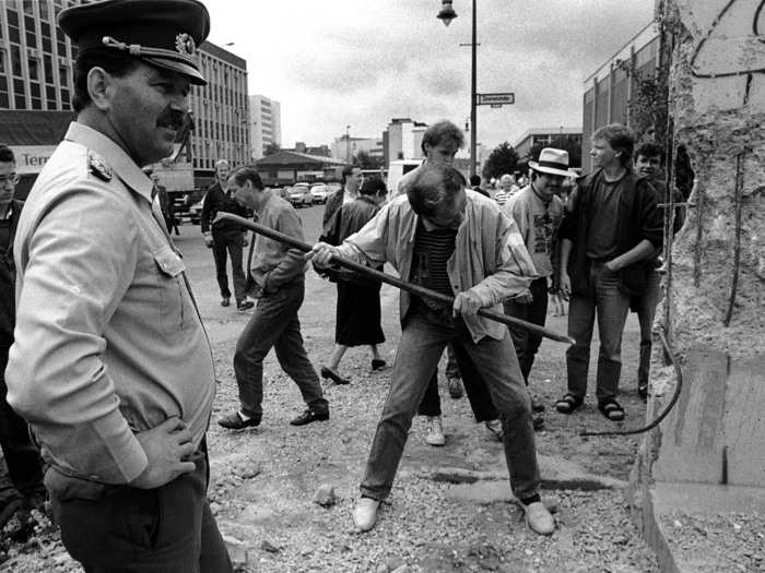 Into the following year, in 1990, citizens still wanted their own piece of the Berlin Wall. Here, a man hammers away at Checkpoint Charlie on June 2, 1990.