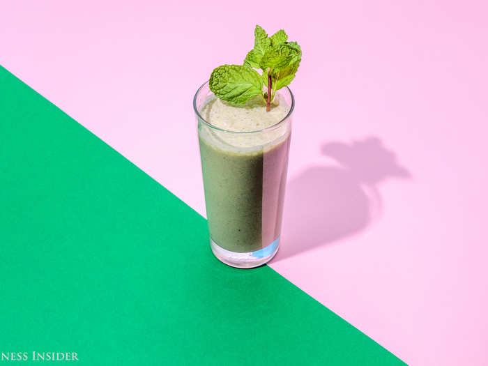 Starting with a half-glass of almond milk, we threw one-and-a-half frozen bananas, a handful of mint, a half teaspoon of extract, a teaspoon of vanilla powder, four squares of white chocolate, and a tablespoon of maple syrup into the blender.