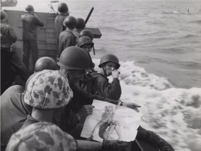 Marines on a landing barge take one last look at a "good-luck picture" of a Pin-Up girl in 1943 while approaching the Japanese-held Tarawa island.