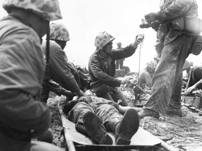 This 1944 photo shows a Navy corpsman giving a wounded Marine blood plasma on an island in the Pacific. Marines captured the island in 24 hours with help from the heaviest naval and air bombardment ever at that time.