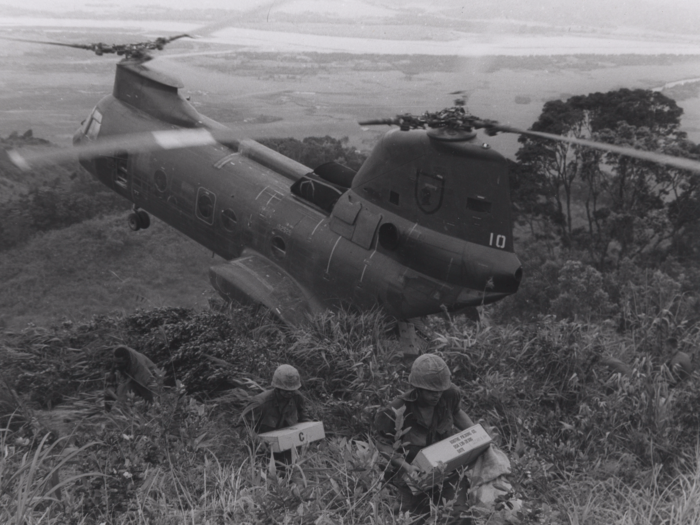 Marines in this 1969 photo carry supplies from a cargo helicopter to their temporary base near Da Nang, Vietnam.