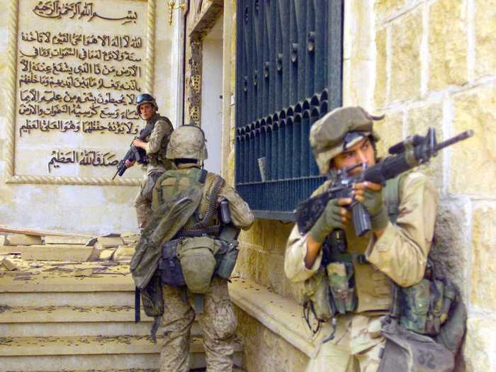 Marines cover each other with M16A2 assault rifles as they prepare to enter one of Saddam Hussein