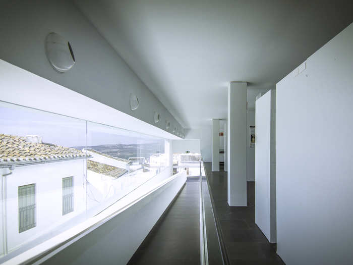 An auditorium slopes in unison with the street. Above are two floors of offices saturated with diffused light that comes through a curtain of sandblasted glass.