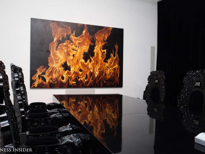 His dining room includes huge chairs that were hand-crafted in Colombia. In the background is a piece called "Fire," by Peter Rostovsky.