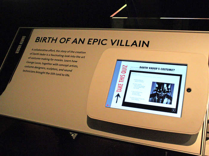 Interactive iPads throughout the exhibit show behind-the-scenes videos and concept art for iconic characters like Darth Vader, Chewbacca, and Obi-Wan Kenobi.