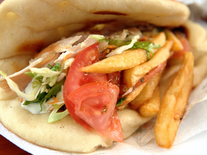 GREECE: To create gyros, thin slabs of pork, beef, or chicken are slowly cooked before being stuffed into warm pita bread and topped with tomato, onion, and Tzatziki sauce.