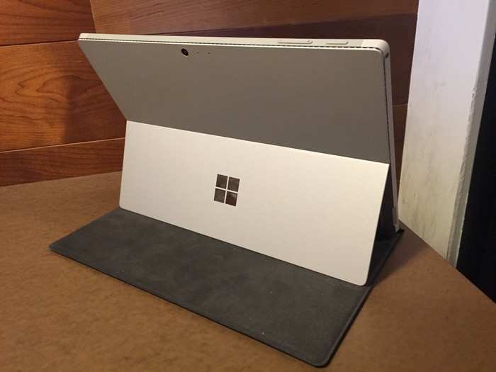 The Surface Pro stands up by using a kickstand that folds out from the back of the device. The disadvantage is that it doesn