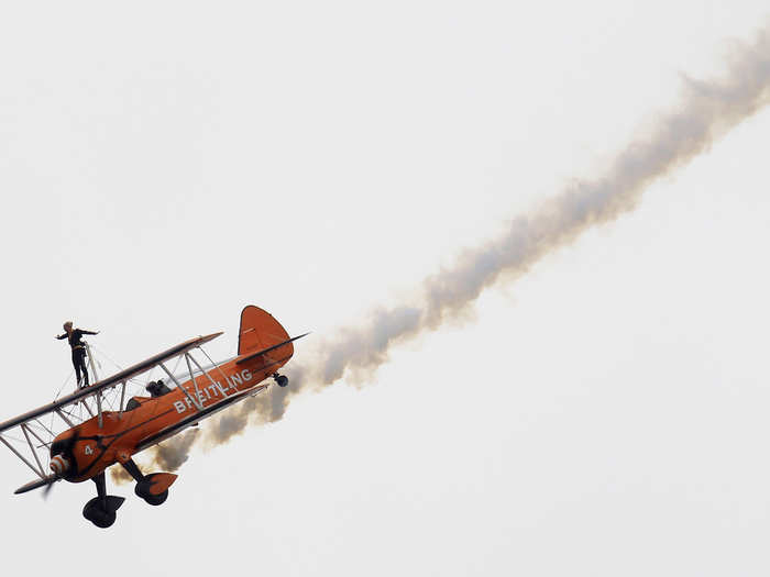 During the 50th Paris Air Show in 2013, a "windwalker" balances along the slim platform atop a Boeing Stearman biplane.