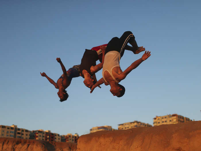 Kids jump through the air as they perfect their parkour skills at the Shati refugee camp in Gaza City, Palestine.