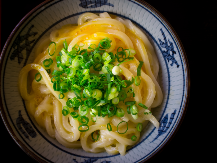 In Sanuki, Japan, dig into a bowl of udon, thick noodles served with a light broth and typically topped with scallions, tofu, and seafood.