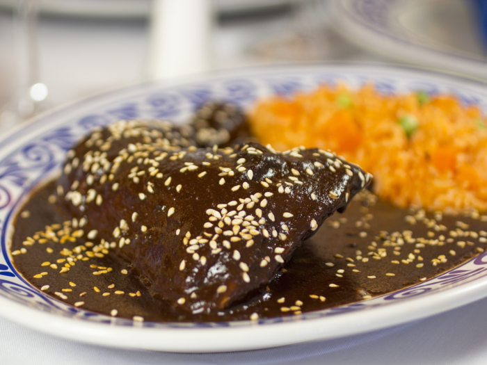 In Puebla, Mexico, enjoy the complex flavors of mole poblano, a thick sauce that is made with chili peppers and chocolate and served over chicken.