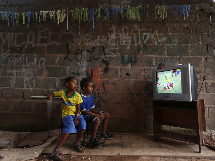 During the World Cup, a couple of young boys on the outskirts of Brasilia watch as their home team, Brazil, plays against Mexico.