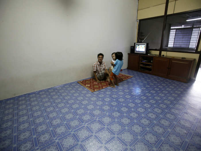 Within Kuala Lumpur, the capital of Malaysia, a Myanmar refugee family sits in the lounge of their empty apartment.