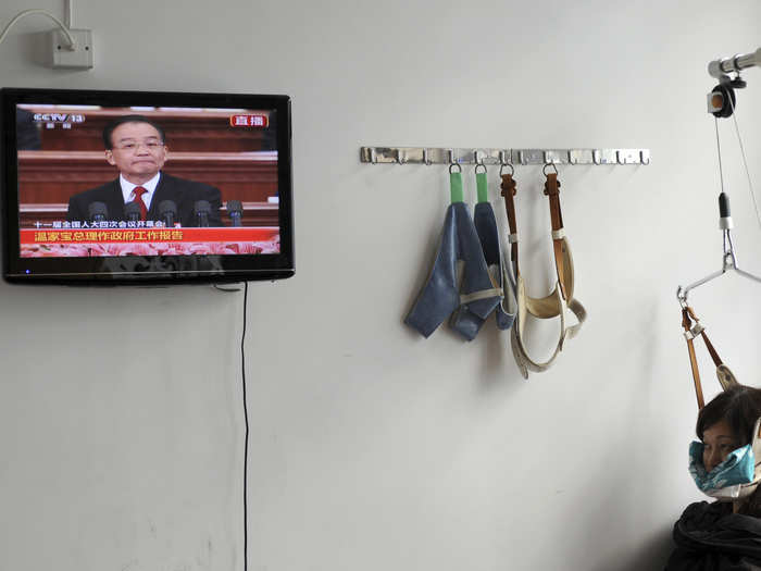 A patient watches a televised government broadcast while receiving medical treatment at a Chinese hospital in Jiaxing.