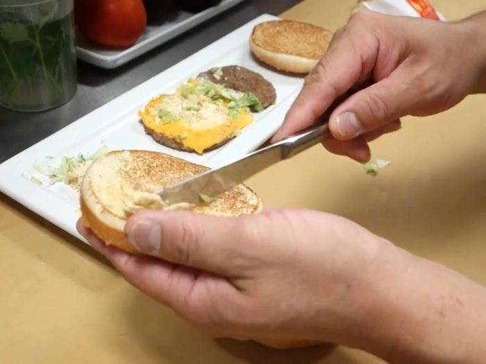 Terada set to work taking apart the burger, separating the buns from the meat, cheese, lettuce, and sauce.